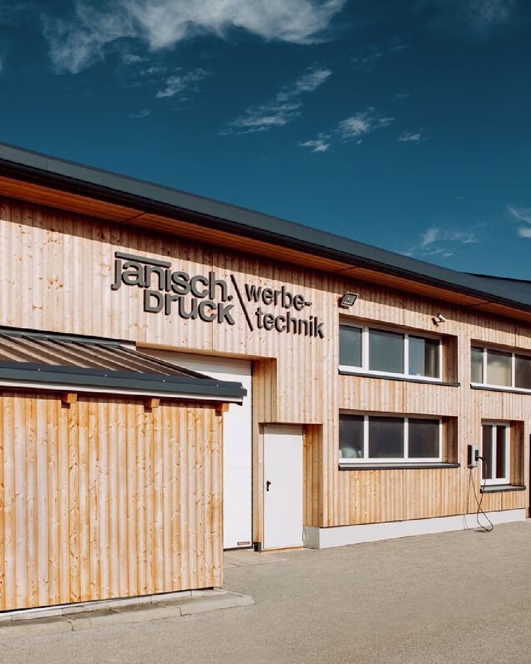 Firmengebäude von Janisch Werbetechnik in Pöllau mit Holzfassade und 3D-Schriftzug