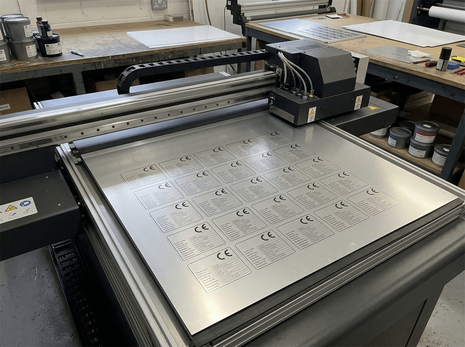 UV-Direktdrucker bedruckt eine Aluminiumplatte mit CE-Typenschildern in der Produktion.